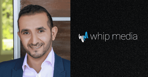 Professional man in business suit smiling, image representing media company Whip Media headquarters and branding for digital media and entertainment analytics.