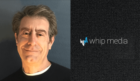 Professional man smiling in a business portrait for Whip Media, showcasing expertise in entertainment technology solutions.