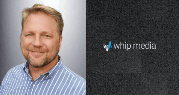 Professional man with blonde hair and beard wearing a blue striped shirt, smiling in front of a Whip Media logo.