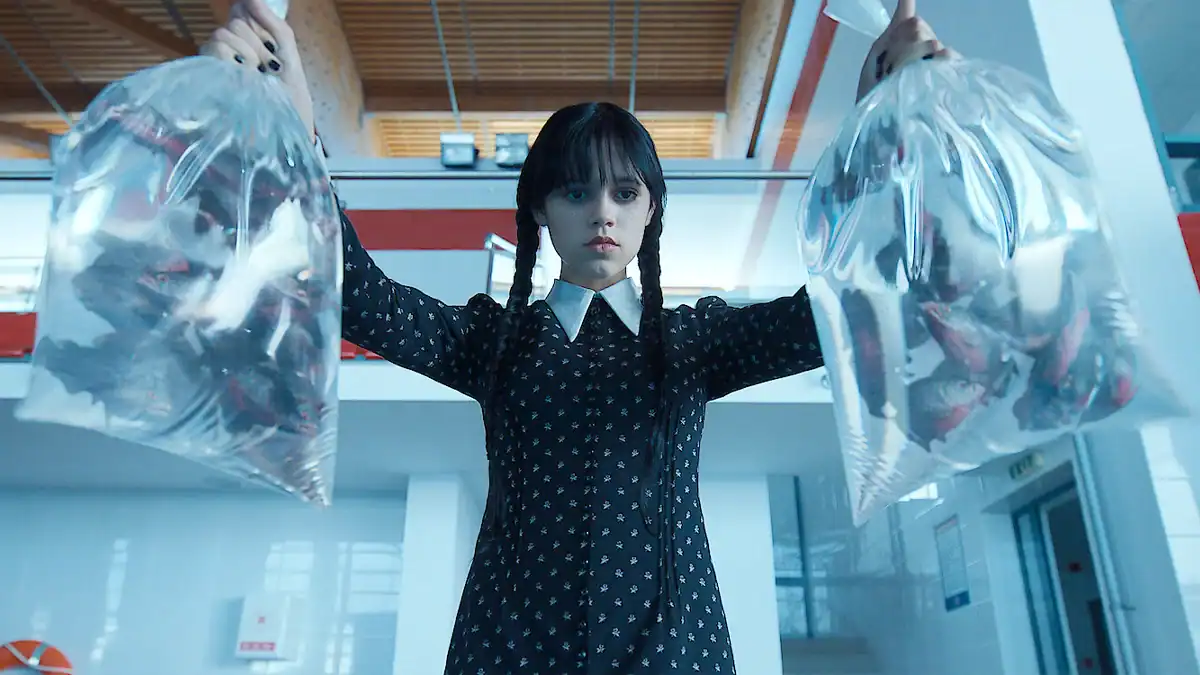 Suspicious girl holding two large transparent plastic bags filled with unidentified items in a modern indoor setting.