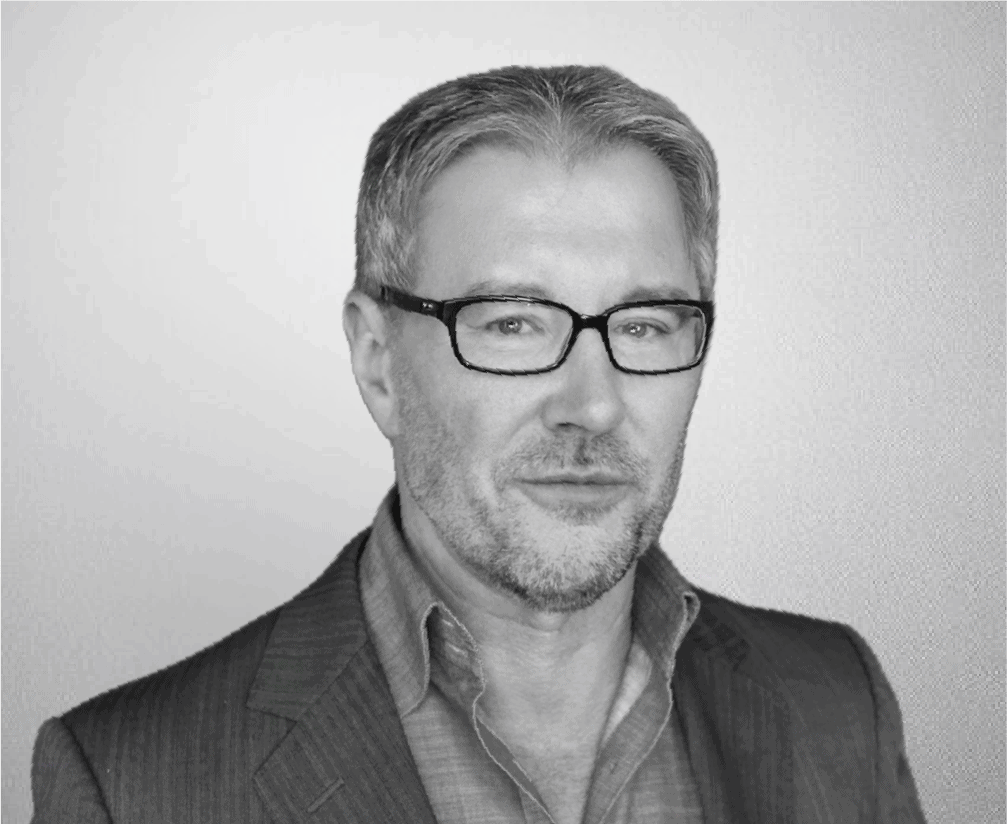 Professional man in business attire wearing glasses, black and white photo.