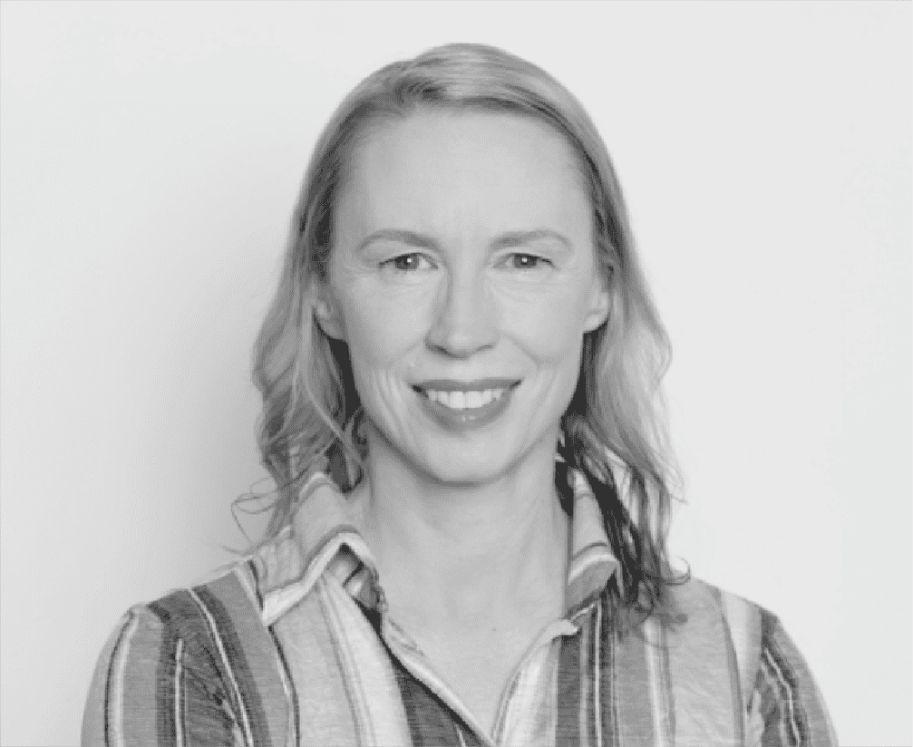 Portrait of a smiling woman in casual striped shirt, black and white photo, professional headshot for media or entertainment industry.