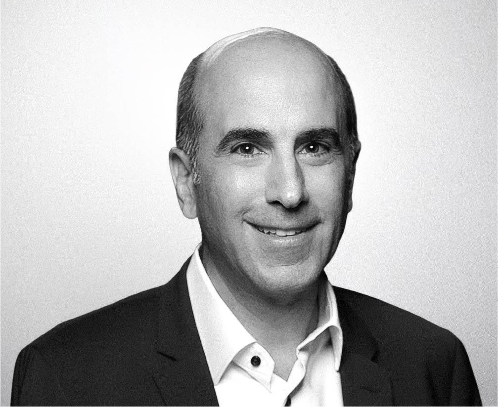 Black and white professional headshot of Bill Gadala in a suit, smiling confidently for business profile.